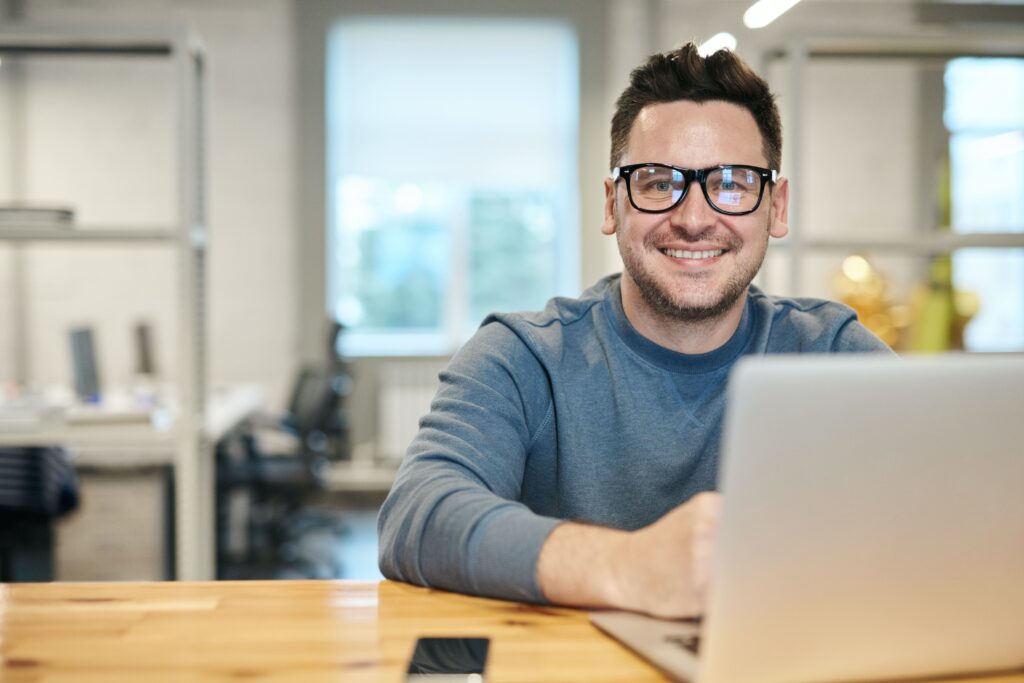 Benefits of using Xero | Man smiling at laptop