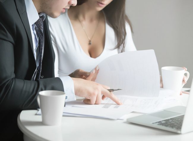 Businessman and businesswoman at office desk, working together w